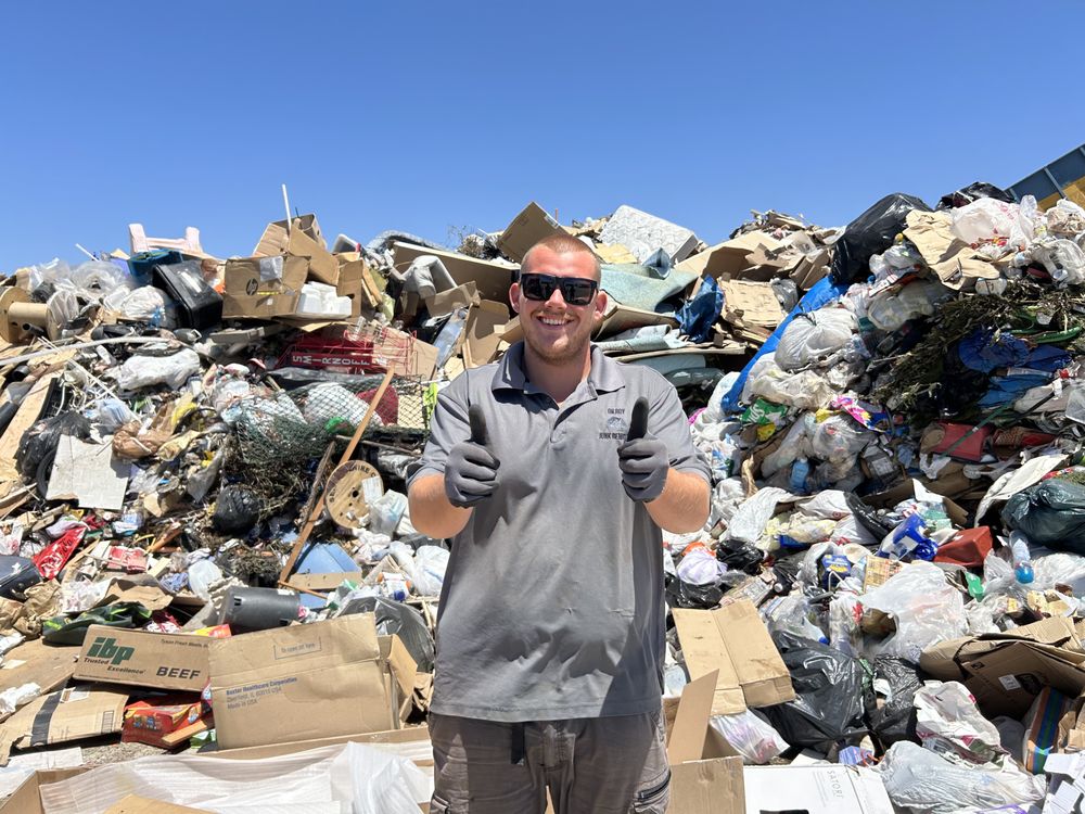 Gilroy Junk Removal crew member giving a thumbs up at the dump site